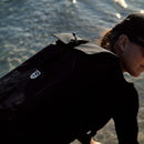 Roll-Top Backpack in green worn on the back, side view with the orange cord