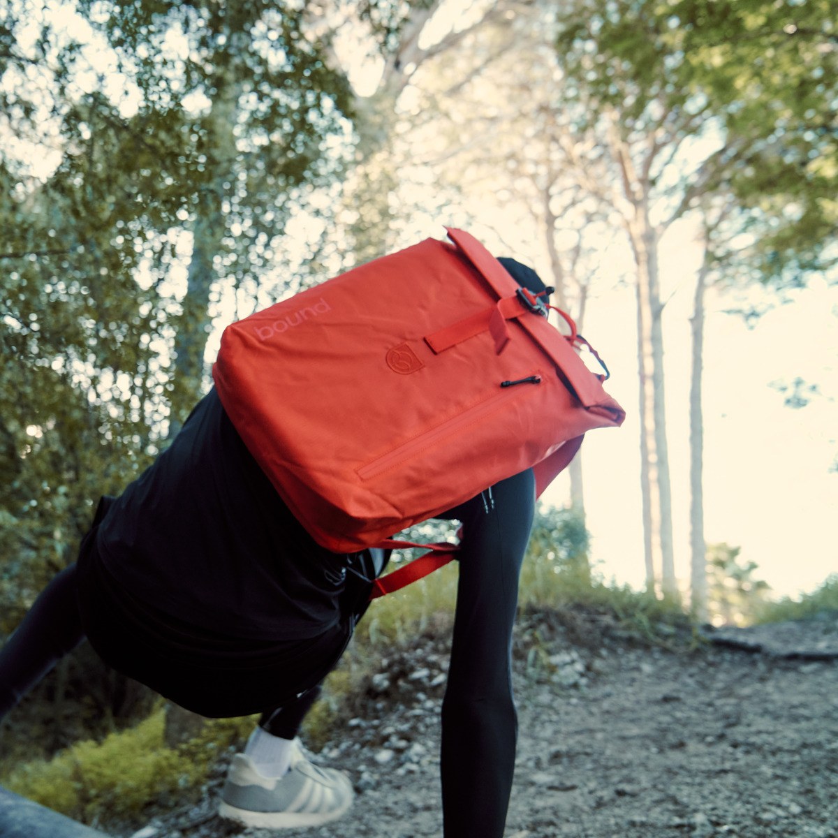 Roll-Top Backpack in green worn on the back, close-up of the roll-top and cord