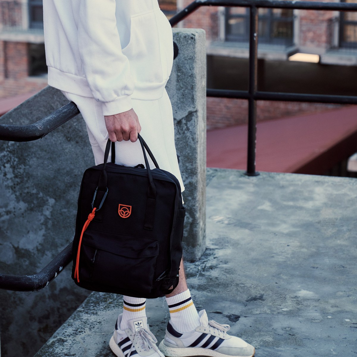 Town Backpack in black worn on the back, rear view by a woman on a city street
