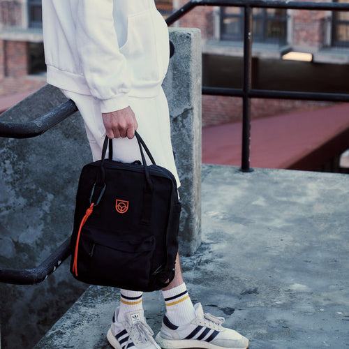 Town Backpack in black worn on the back, rear view by a woman on a city street