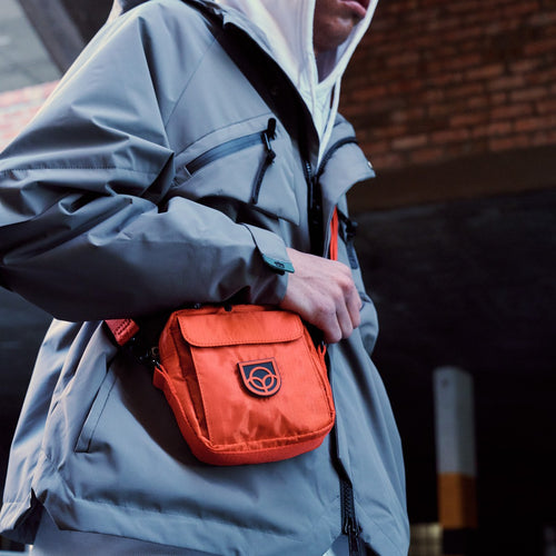 Town Sling Bag in black worn crossbody, side view on a city street
